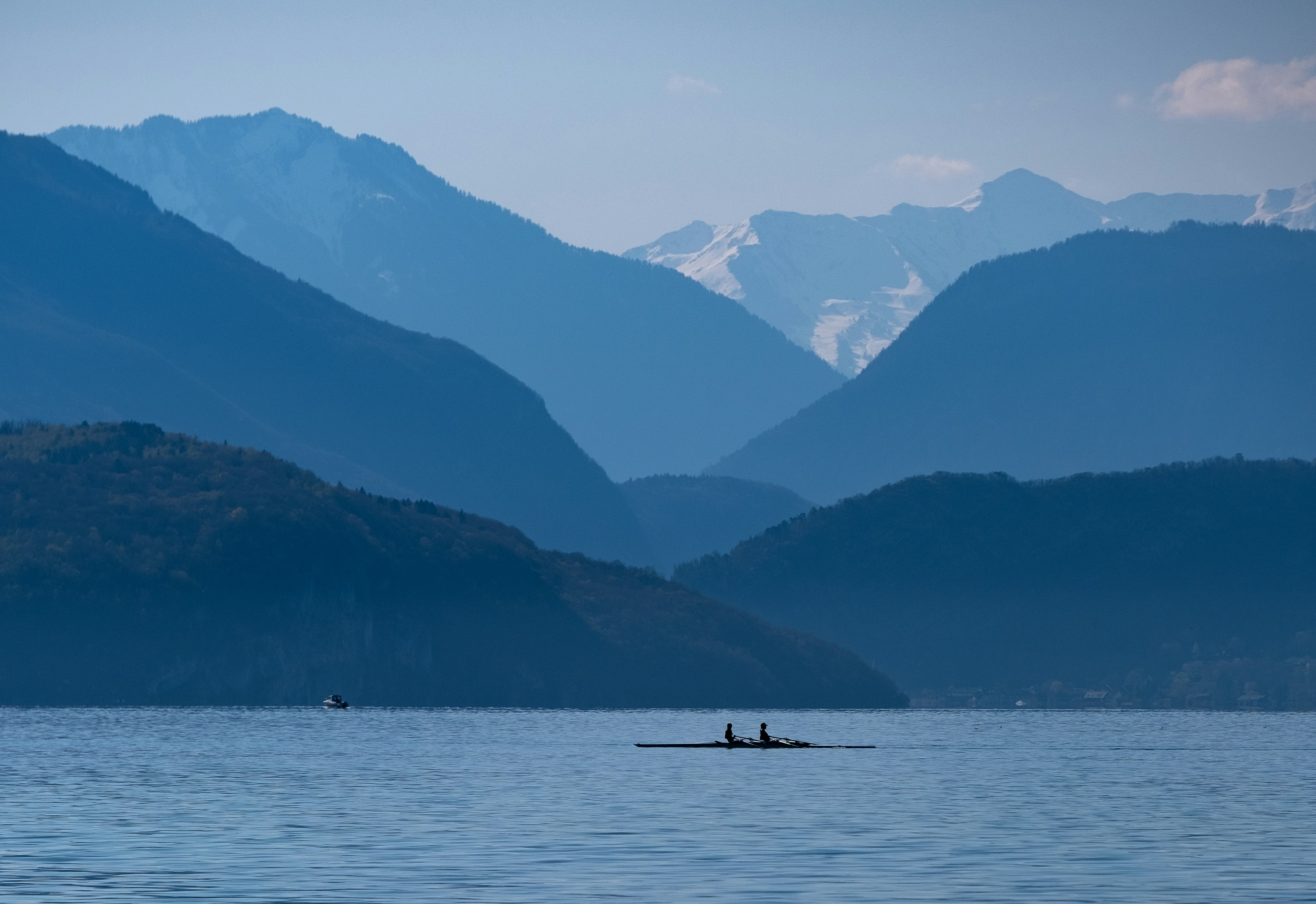 silhouette of 2 people riding boat on lake during daytime